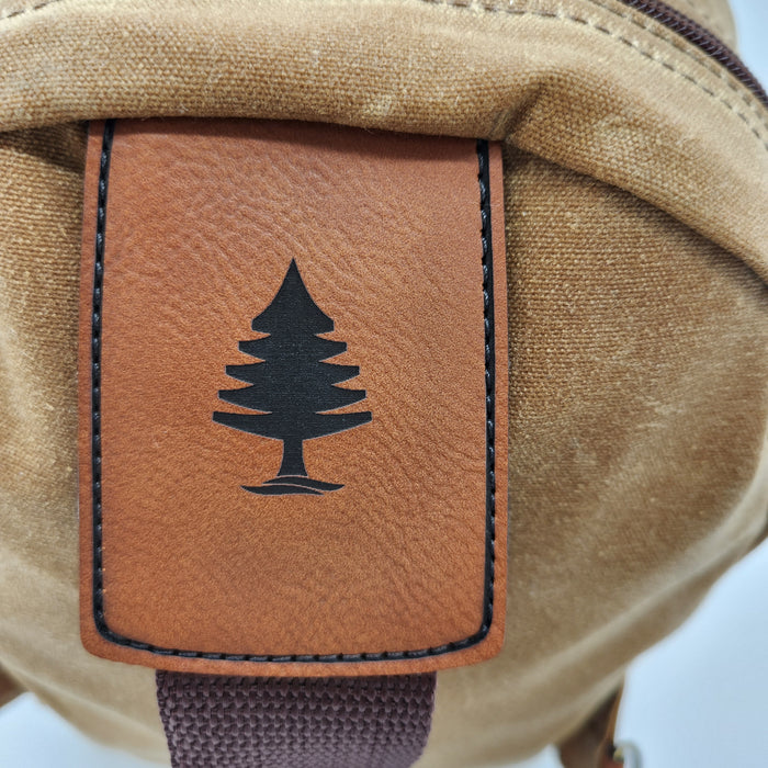 A close up image of the top of the Stella strap, where a leather with a laseer etching of the Rogue Life Logo is sewn to the bag and the strap.